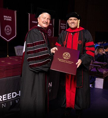 FHU President David R. Shannon presents Keith Harris with his doctorate in ministry in May 2025.