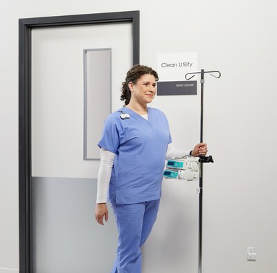 A clinician transports infusion pumps through a healthcare facility using Midmark CareFlow Asset Tracking and BLE technology, delivering near-room location precision to improve medical equipment visibility and utilization.